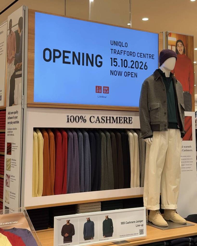 mannequin in uniqlo trafford centre store with opening date sign and row of different colour cashmere jumpers