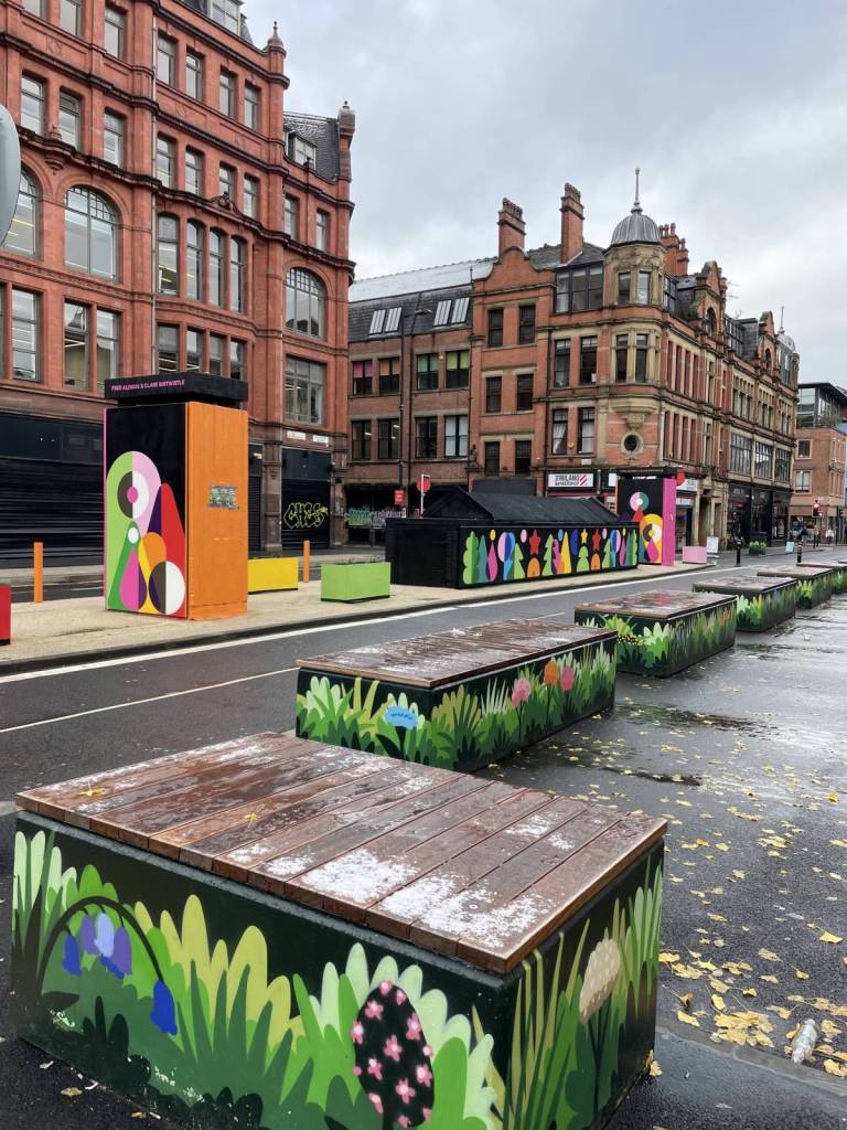 bollards painted with leaves and insects in stevenson square in manchester