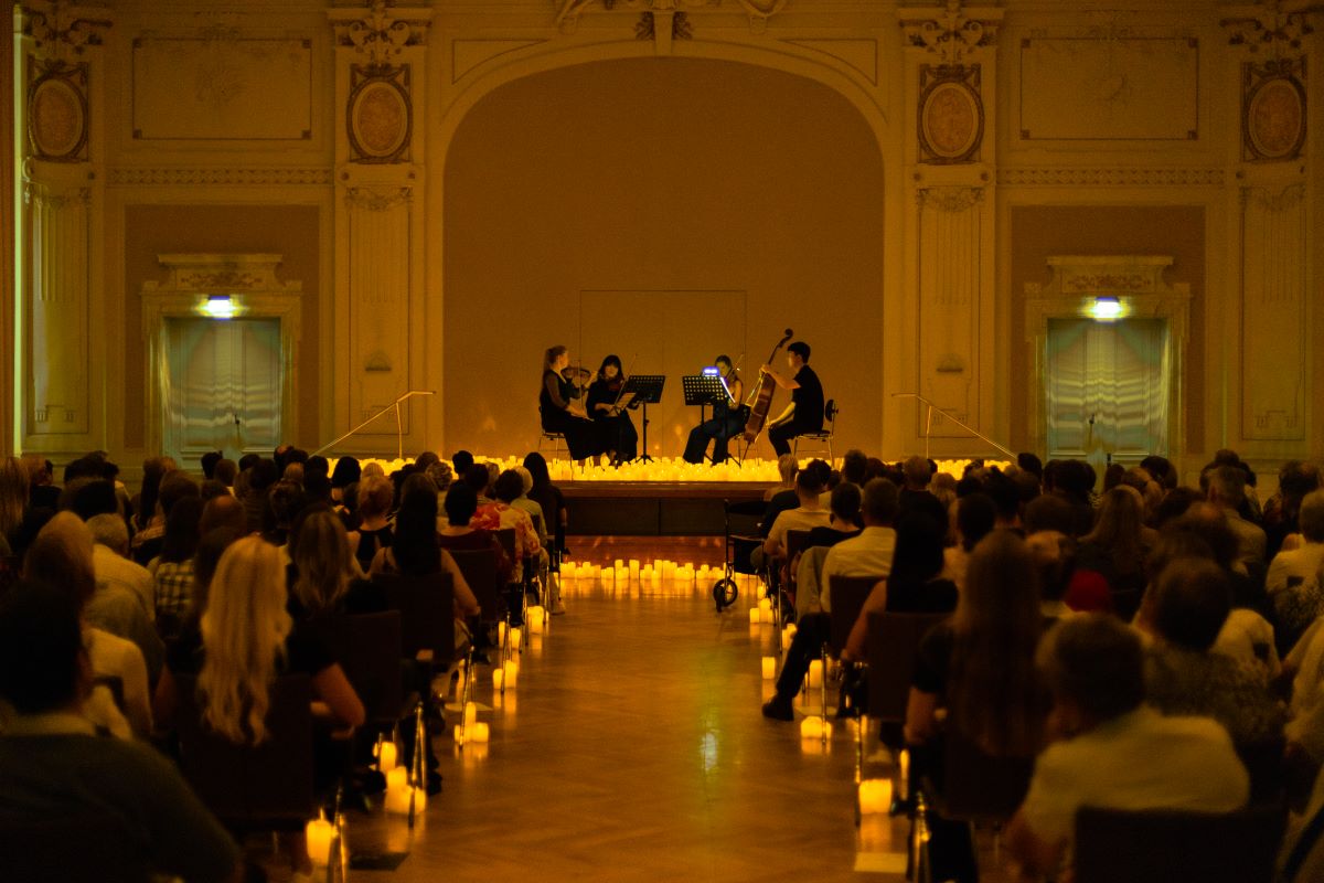 Candlelight-Konzert in der Historischen Stadhalle Wuppertal, Streichquartett spielt auf der Bühne umringt von zahlreichen Kerzen, Zuschauer sitzen im Vordergrund