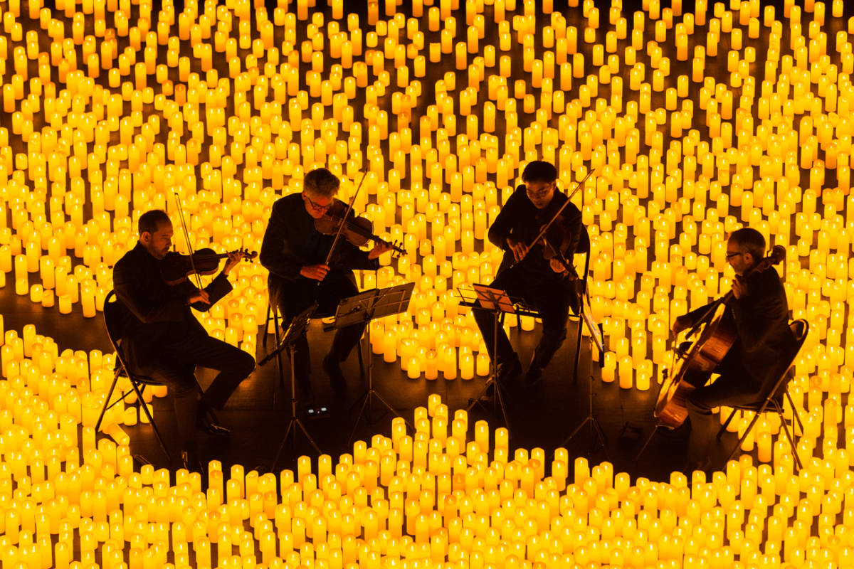 Streichquartett spielt auf der Bühne bei einem Candlelight-Konzert von Kerzen umgeben