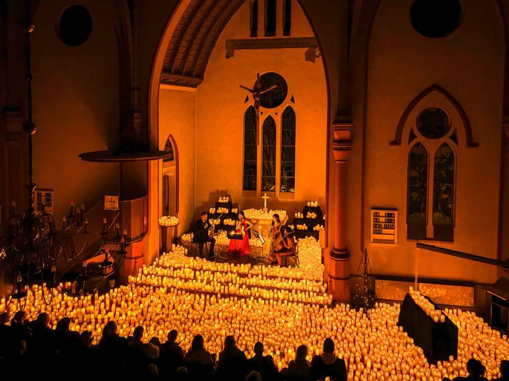 Candlelight-Konzert in der St. Jakobi Kirche in Bremen, Streichquartett spielt auf der Bühne, umgeben von etlichen Kerzen