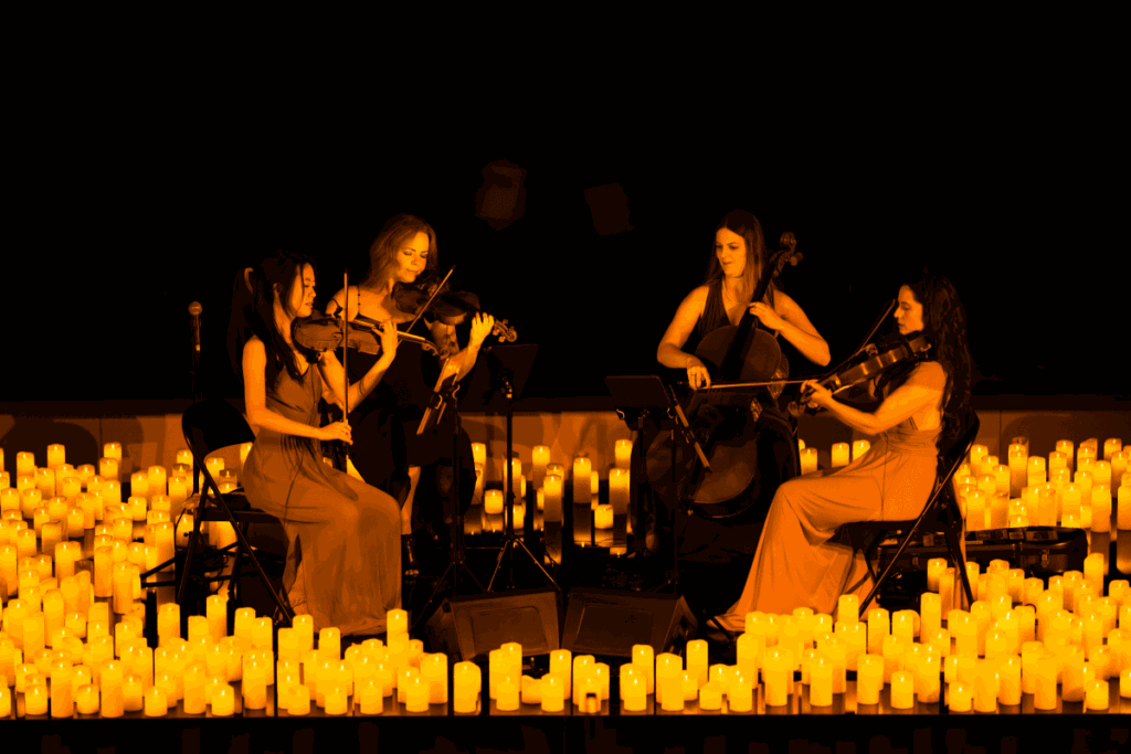 A string quartet plays on a candlelit stage at a Candlelight concert.