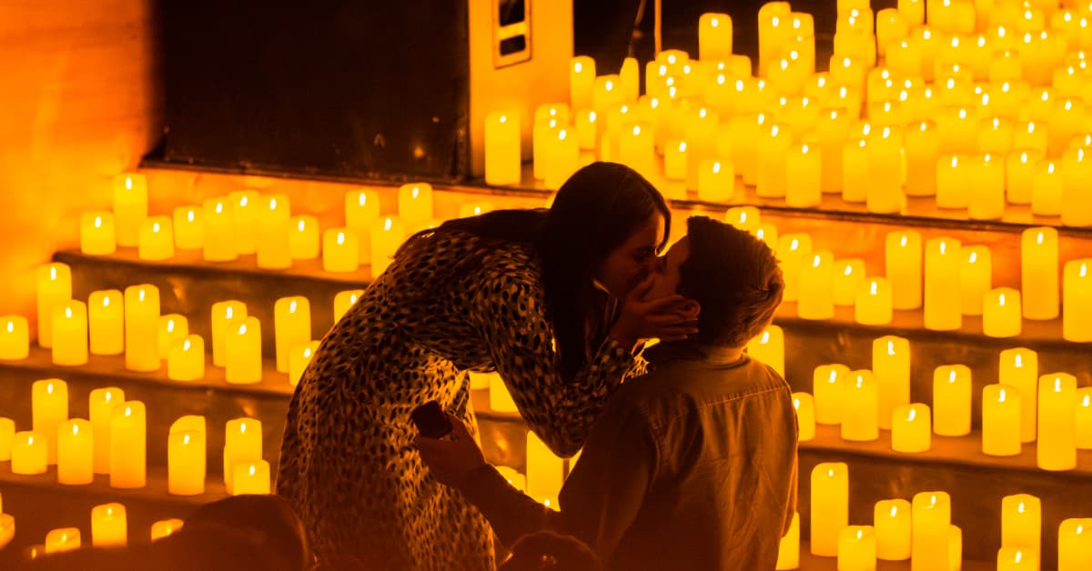 Una pareja delante de un escenario cubierto de velas Candlelight.