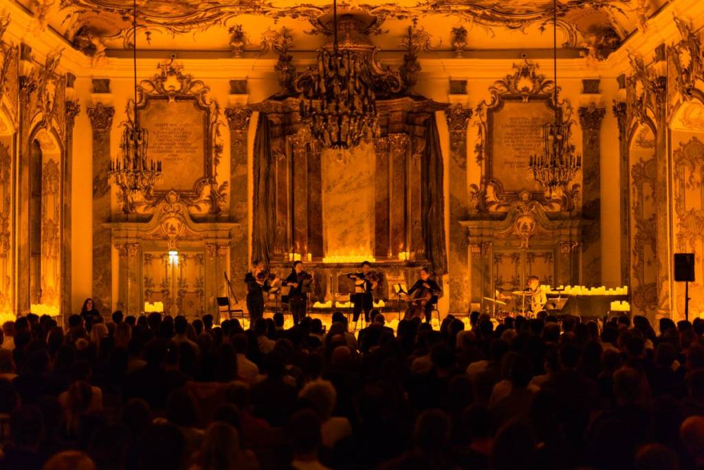 Candlelight-Konzert im Kleinen Goldenen Saal in Augsburg, Streichquartett spielt auf der Bühne in prunkvollem Ambiente und mit Publikum im Vordergrund