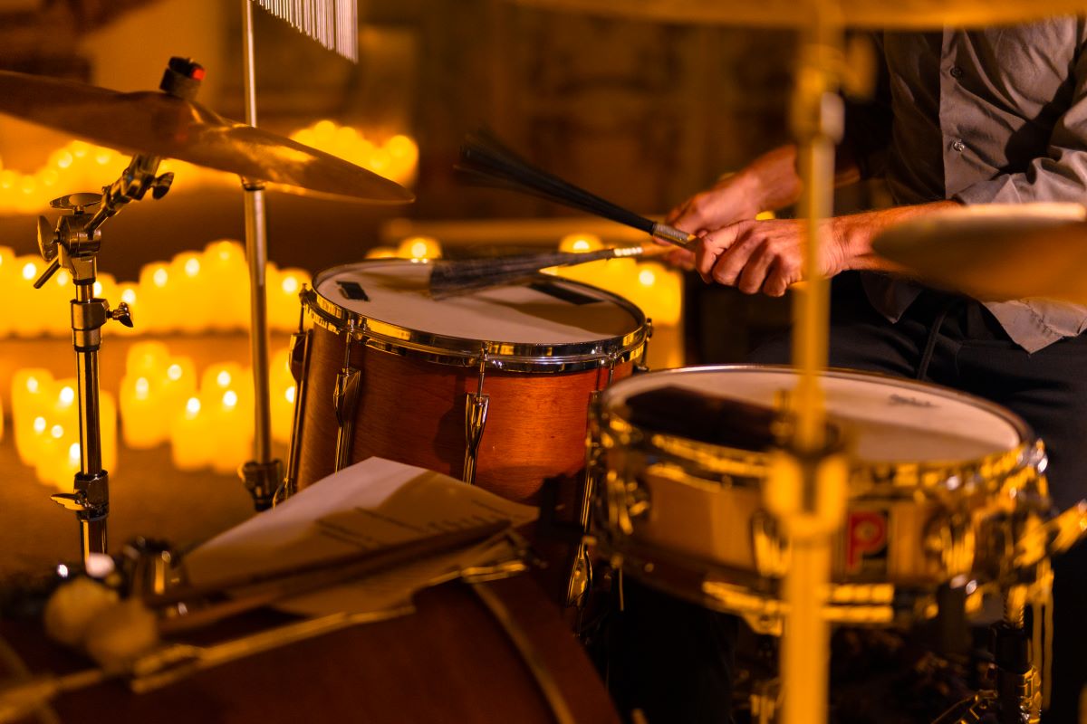 Nahaufnahme von einem Schlagzeuger bei einem Candlelight-Konzert, Kerzen im Hintergrund