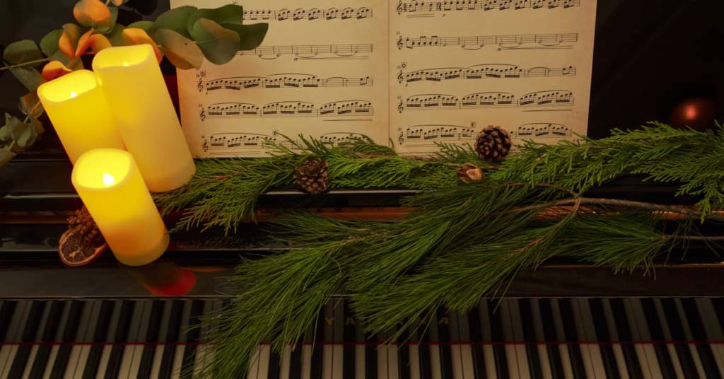 pianoforte decorazioni di natale spartito con le note e candele luminose