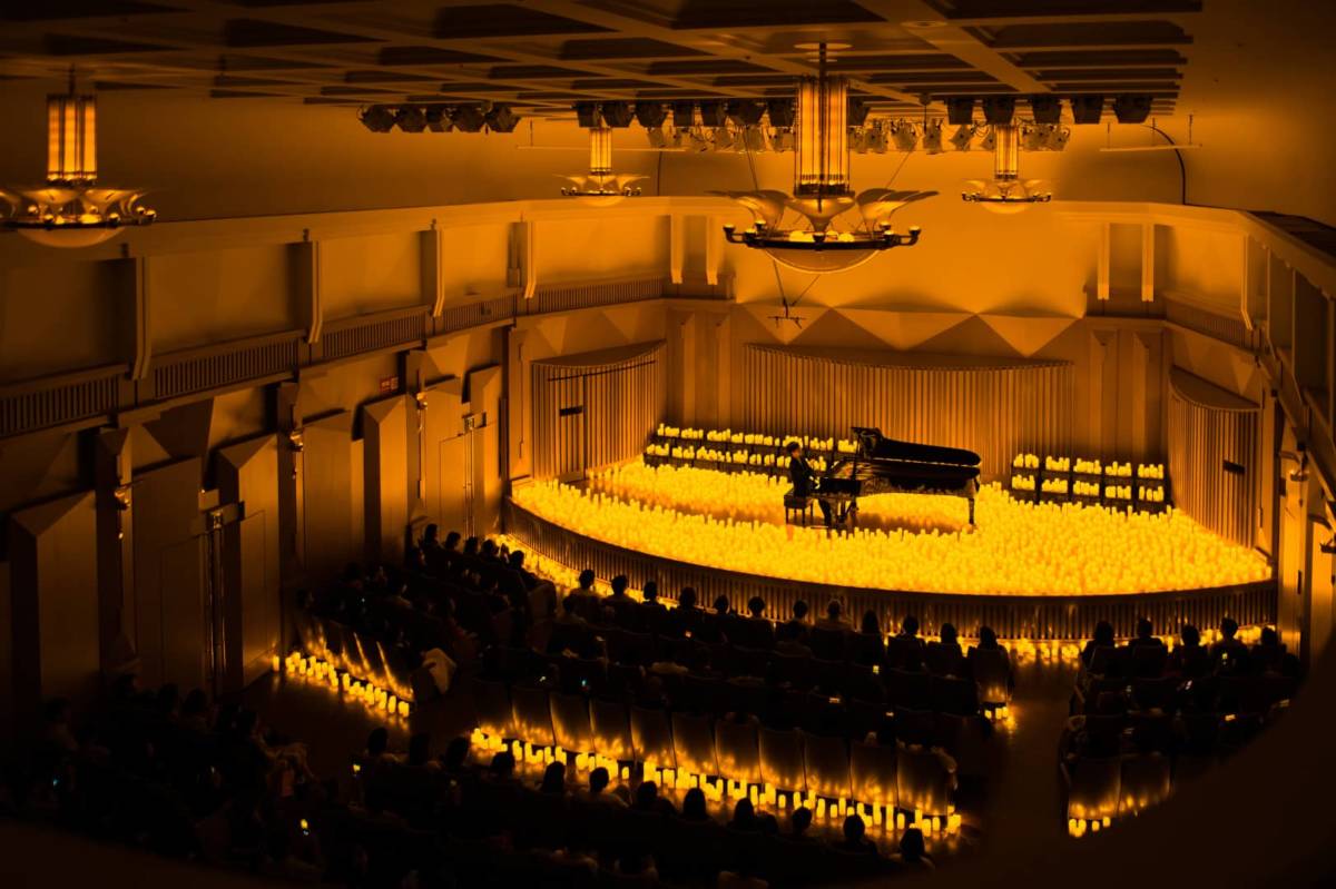 A pianist performing at Oji Hall amid a sea of candles