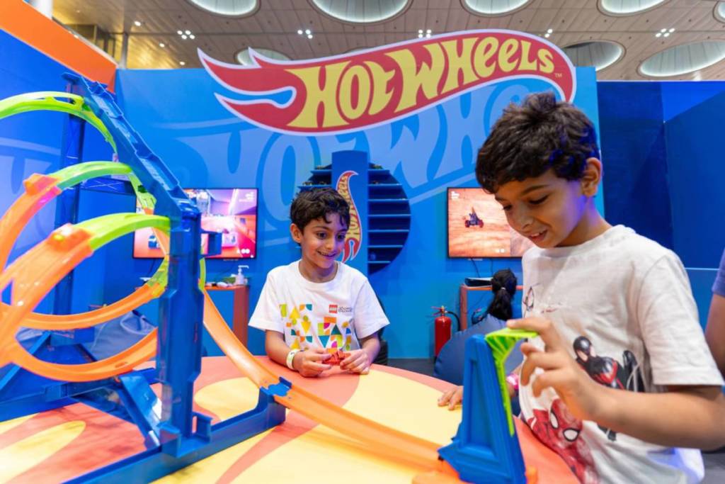 Children at Qatar Toy Fest playing with a Hot Wheels building set