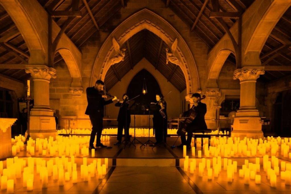 quarteto de cordas em palco iluminado por milhares de velas nos concertos candlelight