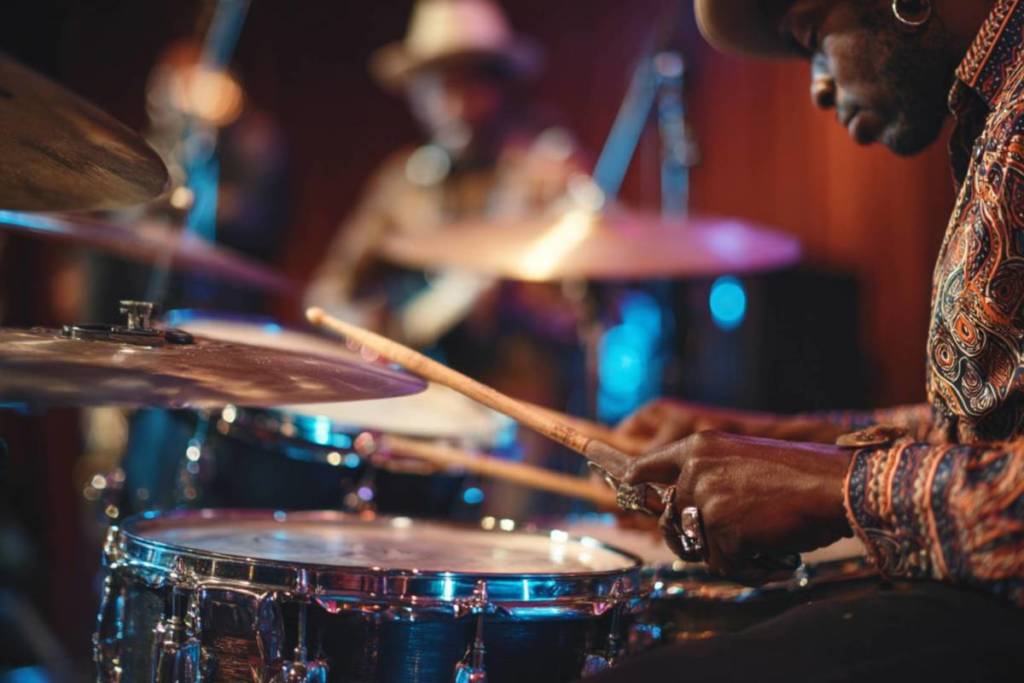 A man plays the drums with a dark backdrop at We call it Jazz: Blues.