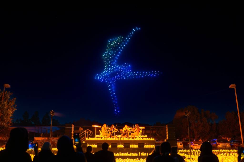 Illuminated drones fly over a string quartet