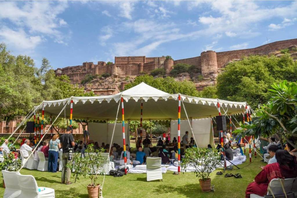 A tend providing shade for a crowd to enjoy festivities and performances