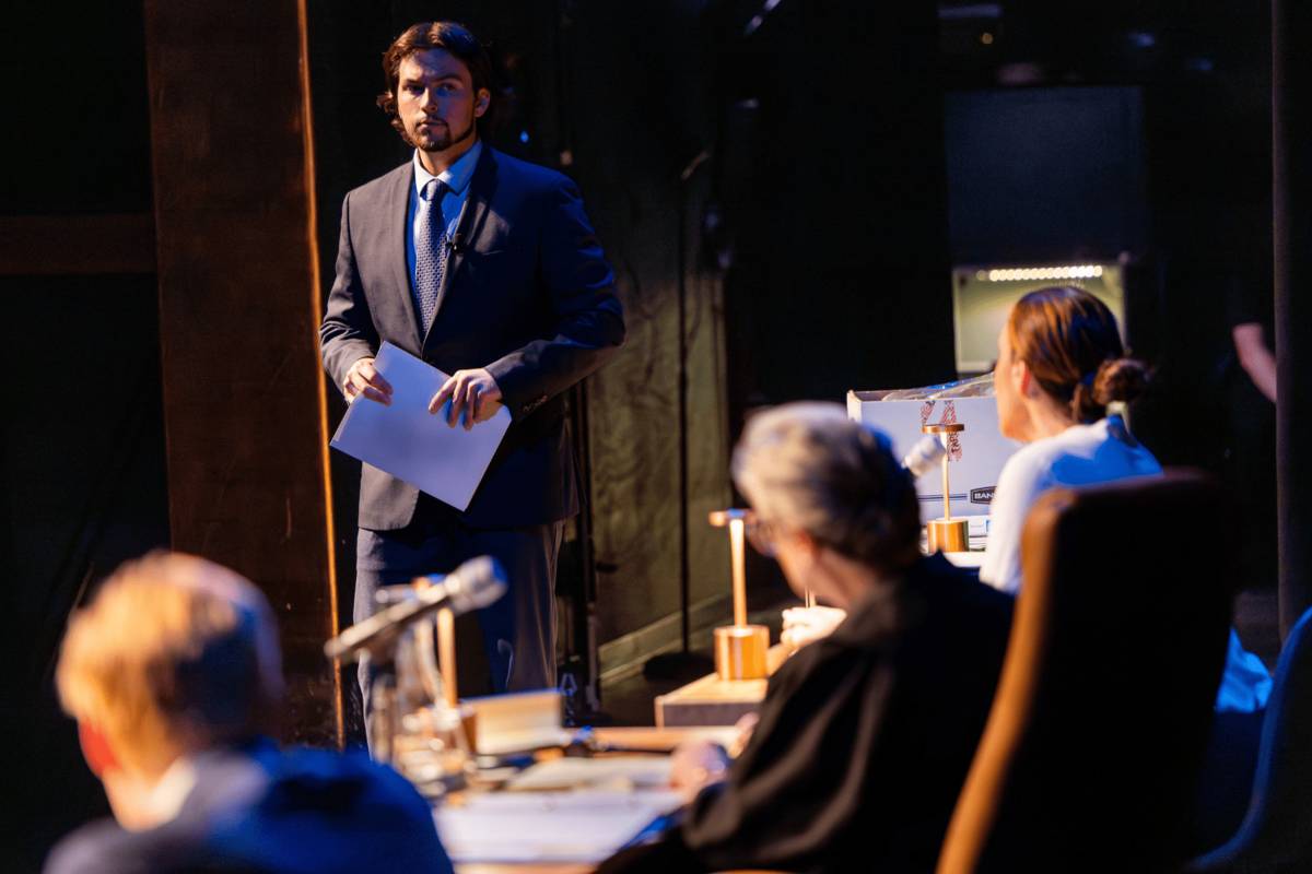 Een advocaat staat met documenten in de hand voor de rechterstoel tijdens The Jury Experience