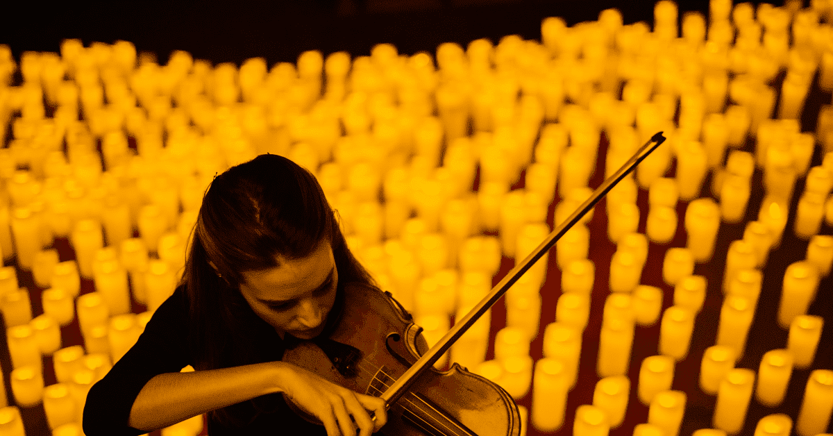 A musician playing the violin surrounded by a sea of candles during a Candlelight concert