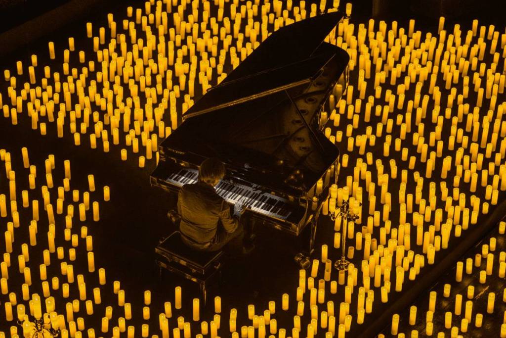 Un pianista suona durante un concerto Candlelight a Padova circondato da mille candele