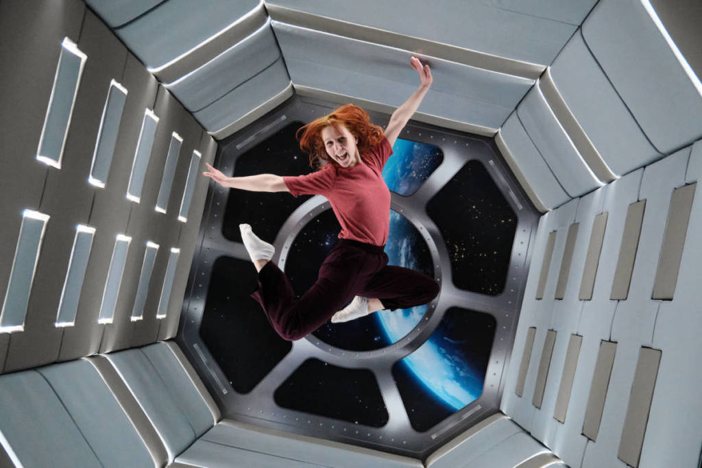 a woman jumps in the air in the Zero Gravity Room at the Paradox Museum