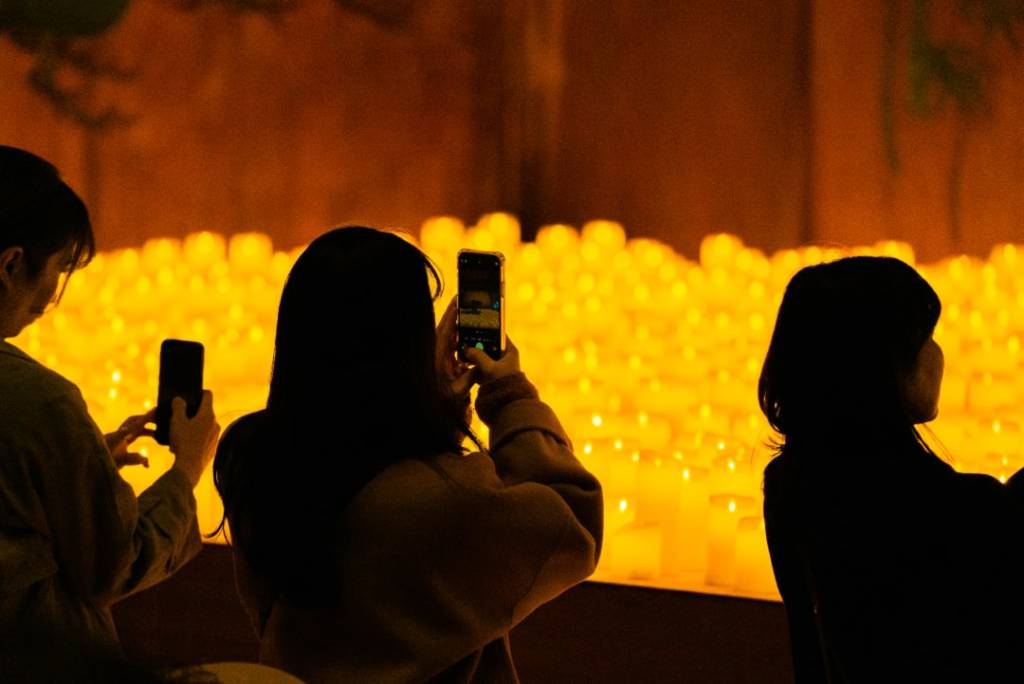A person records a Candlelight concert on their phone.