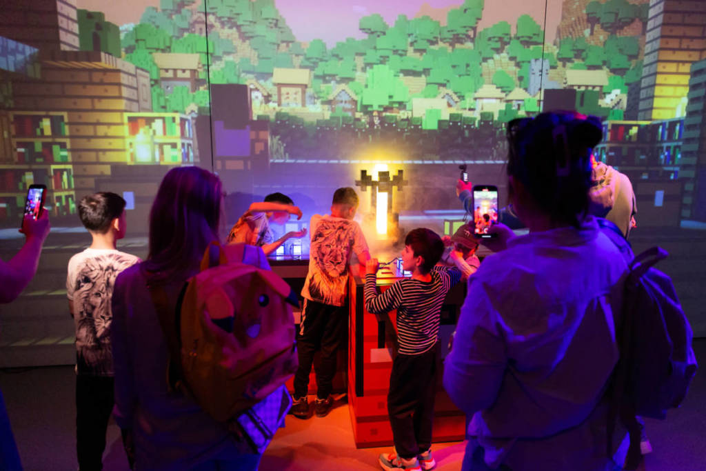 a few families use their orbs to interact with the digital world at Minecraft Experience: Villager Rescue