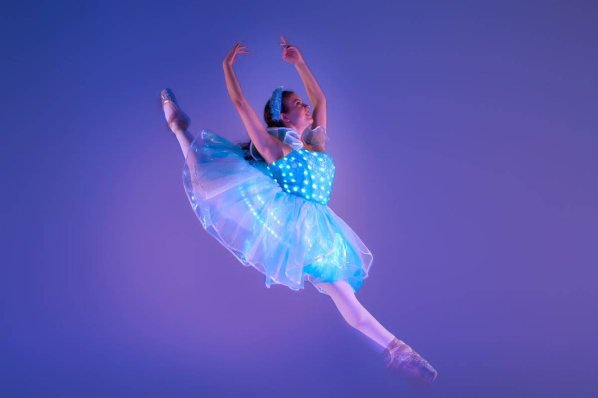 dancer jumps on stage in costume on stage at ballet of lights