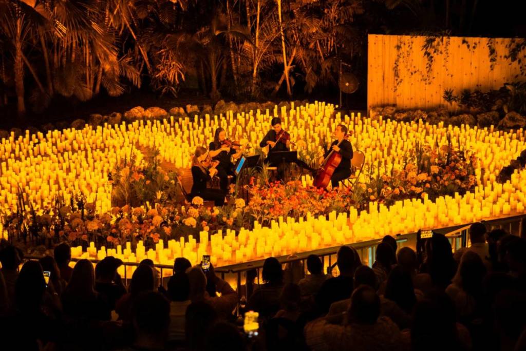 Streichquartett spielt auf der Bühne von Candlelight Spring, umgeben von zahlreichen Kerzen und Blumen