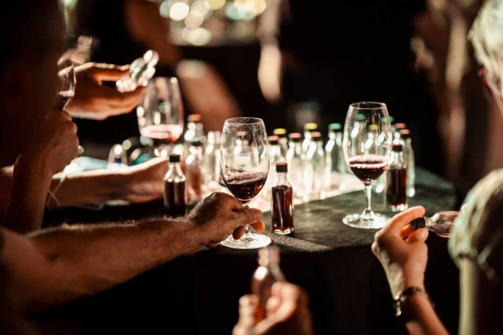 Close up of guests of An Idiot's Guide to Wine swirling wine glasses
