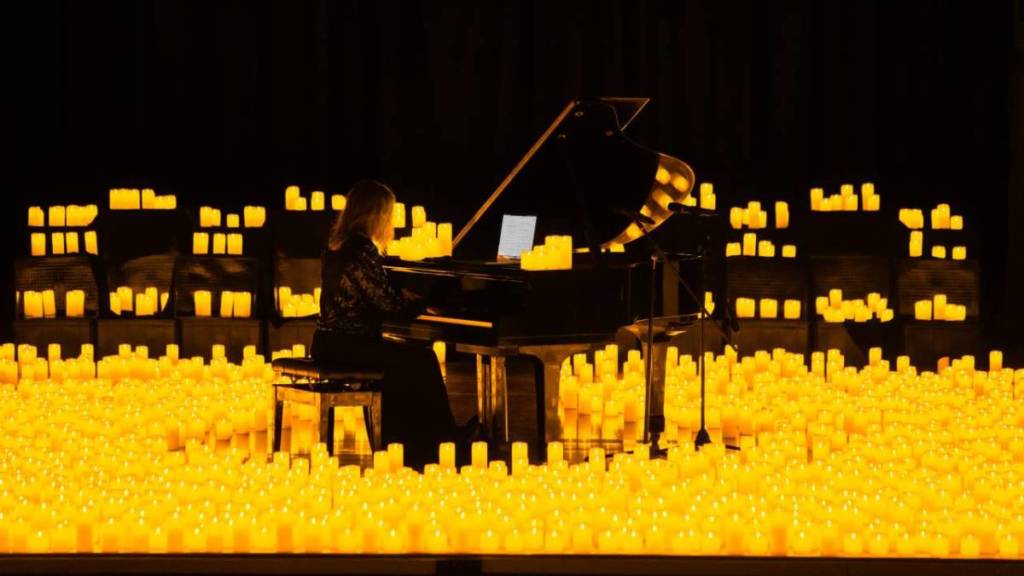 A pianist performing at a Candlelight concert amid a sea of candles