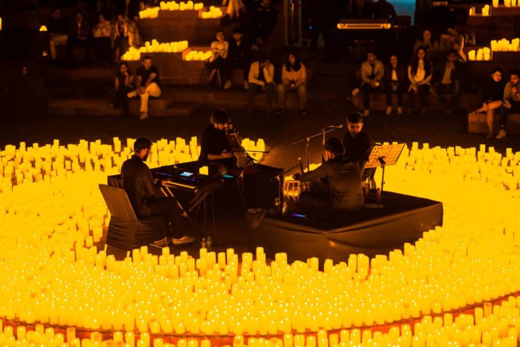 Streichquartett spielt bei einem Candlelight-Konzert auf der Bühne, umgeben von etlichen Kerzen