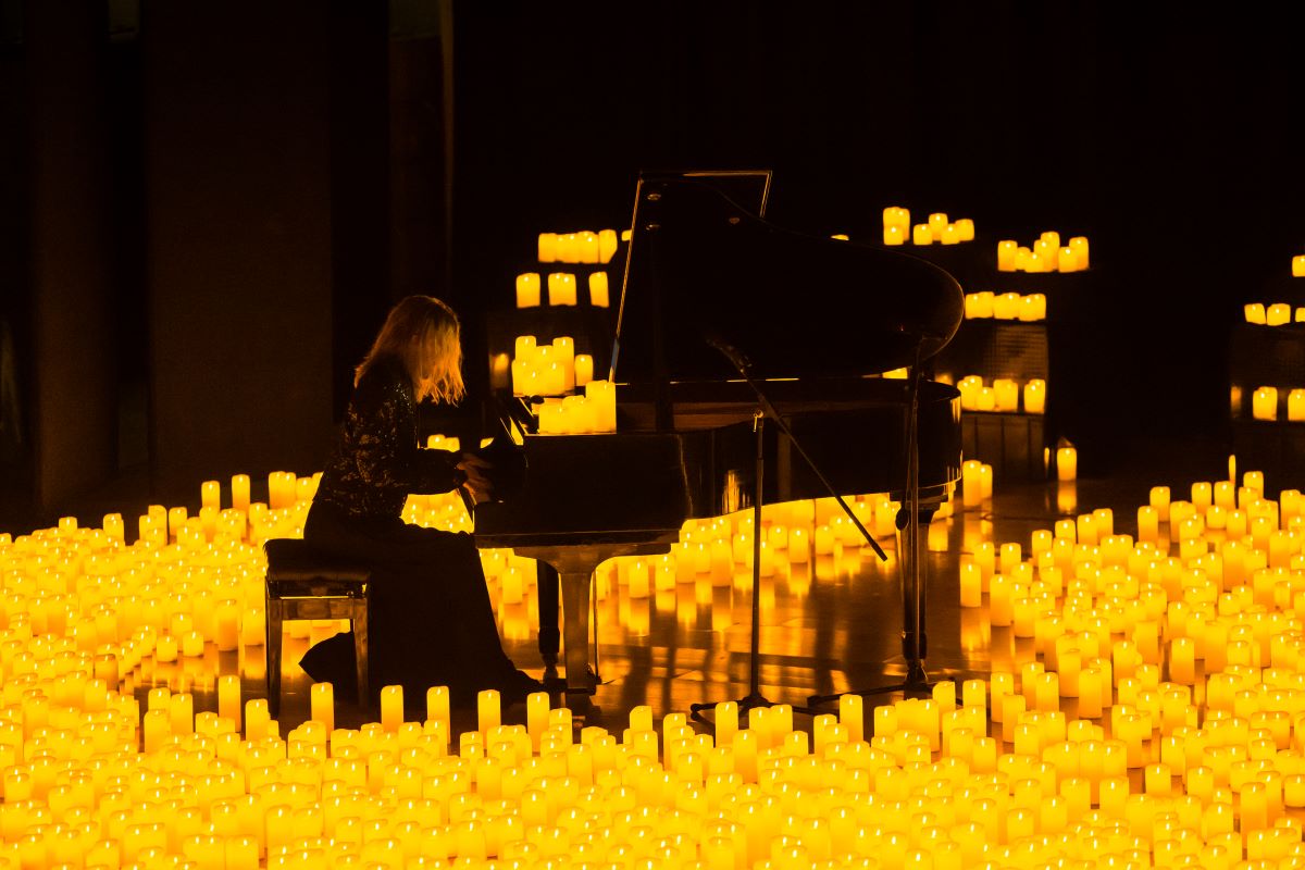 A musician playing the grand piano surrounded by thousands of candles