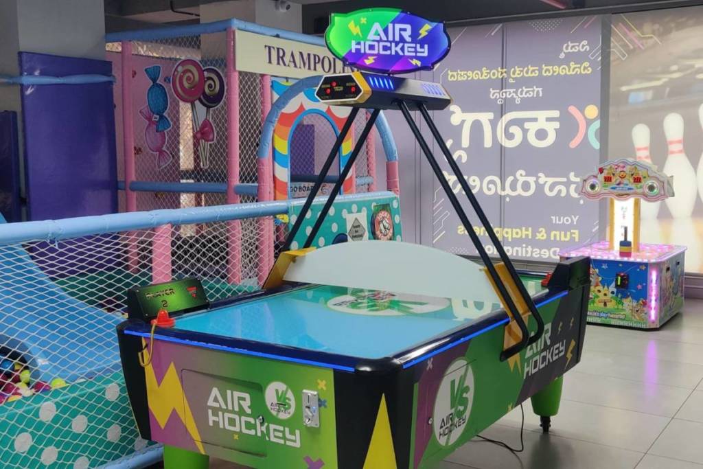 An air hockey table stood in the foreground, of a trampoline area