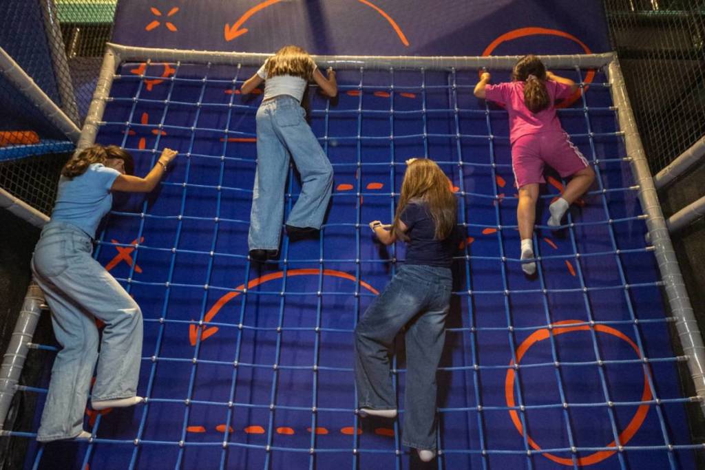 Four children climbing NERF Action Xperience's rock climbing wall