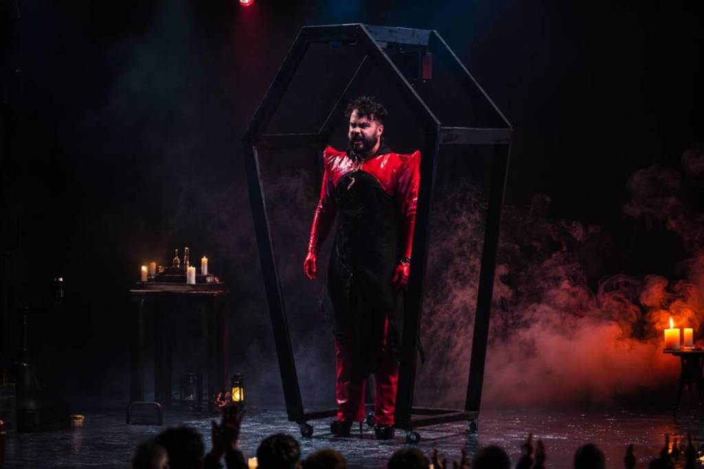actor standing in coffin