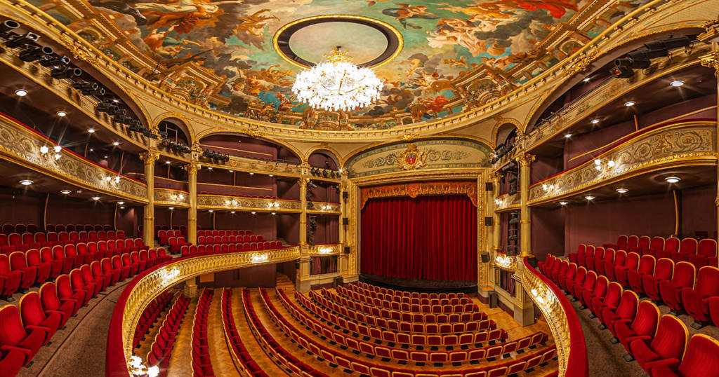 Photo de l'intérieur du Grand Théâtre d'Angers (sur la place du Ralliement) avec sa scène majestueuse et ses sièges de velours rouge