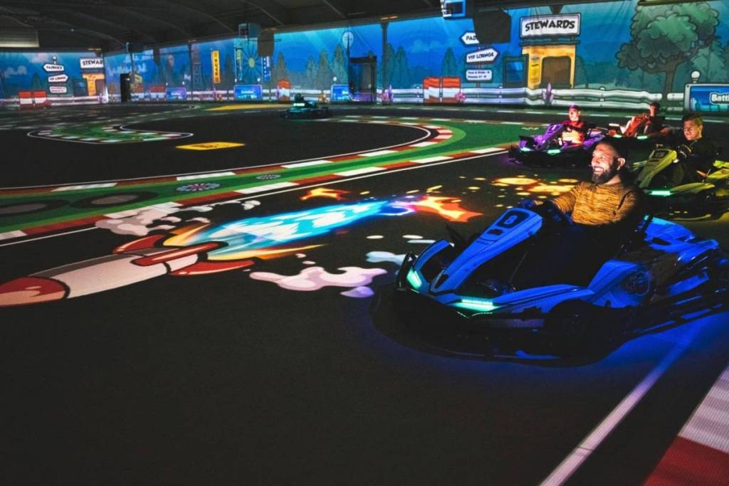Gruppe von Spielern in Elektro-Karts auf der interaktiven BattleKart Bahn in Fürth mit digitalen Effekten und Power-Ups auf dem Boden