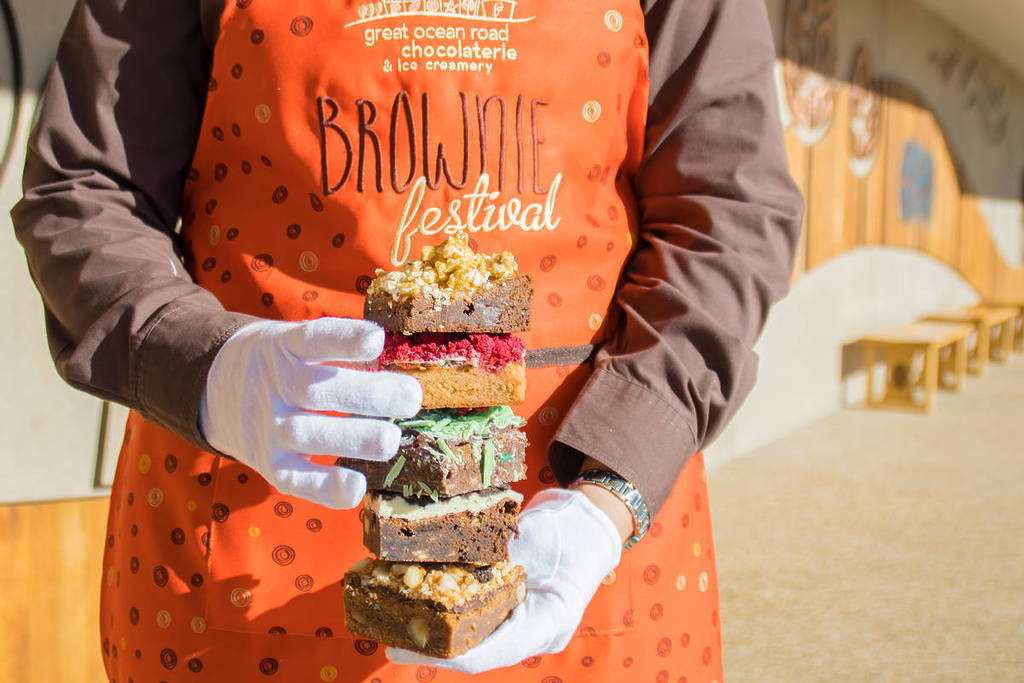 someone holding a stack of different brownie flavours at the Brownie Festival
