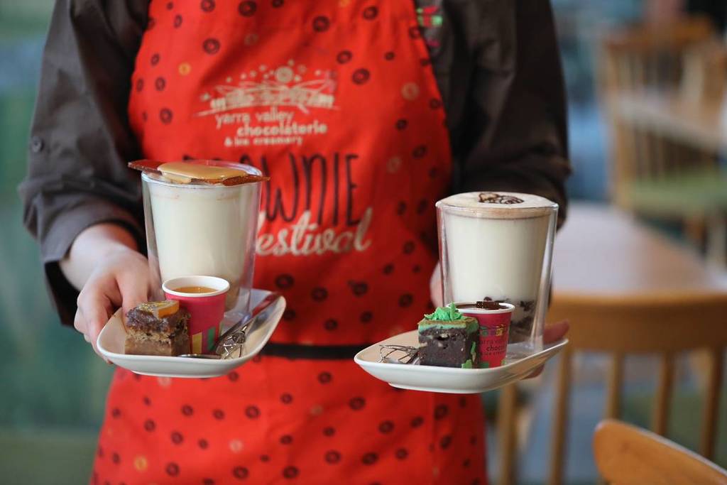 someone holding two brownie-inspired hot chocolates