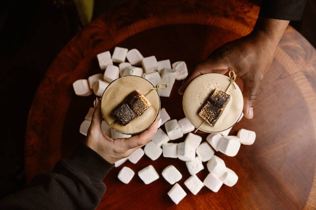 two hot chocolates surrounded by marshmallows