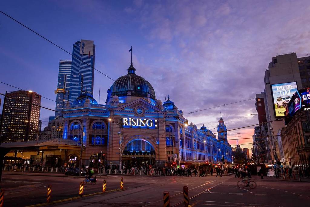 a sign that says RISING on Flinders Street Station, a festival that's one of the things to do in Melbourne in June