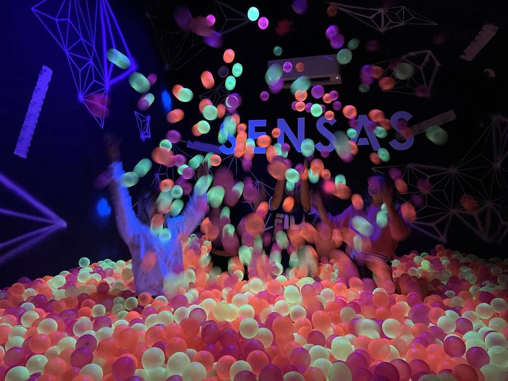 People play in a ball pit at SENSAS