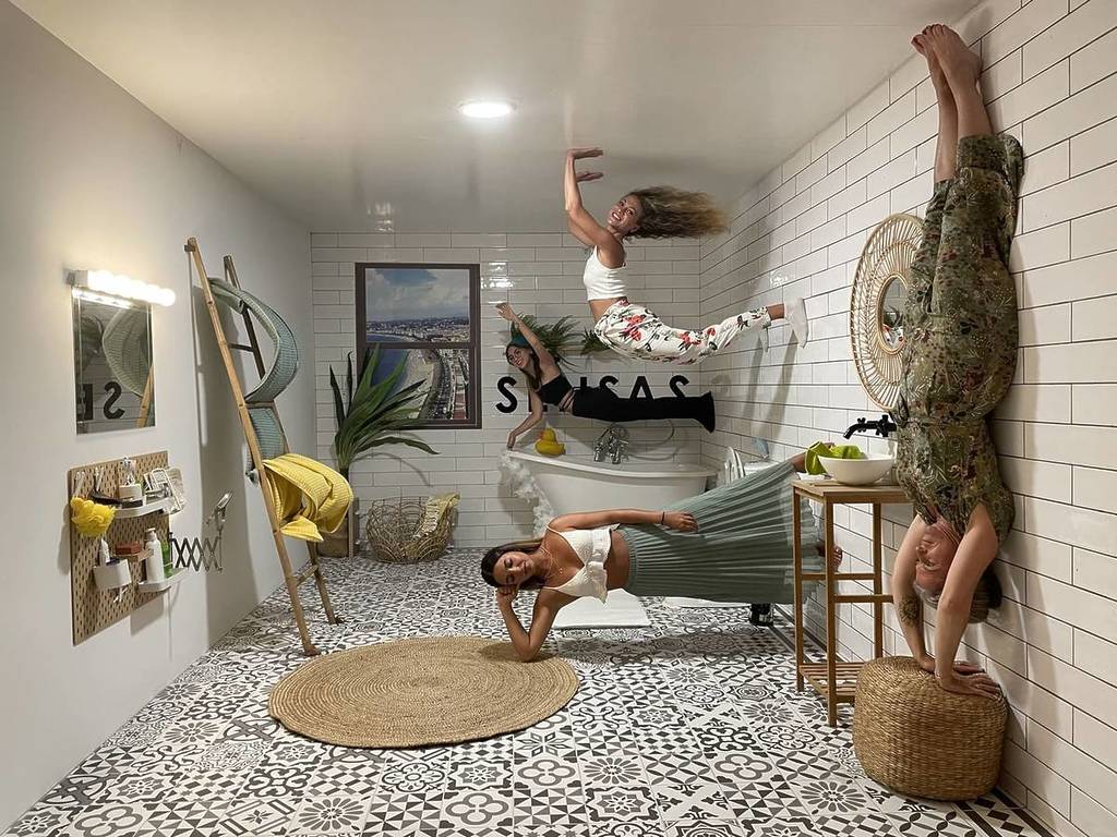 Four women pose for a photo in the inverted room at SENSAS.