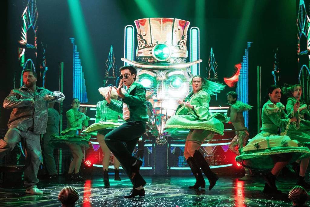Performers dressed in green dance on stage at Oz: The Cirque Experience.