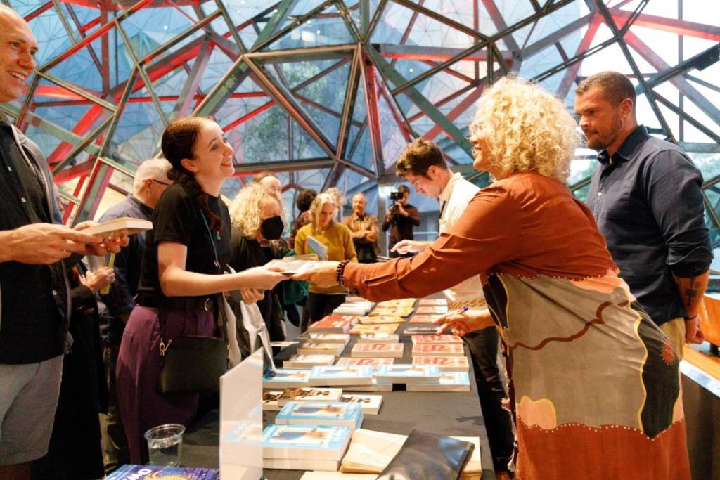 author giving out books at Blak and Bright Writers Festival