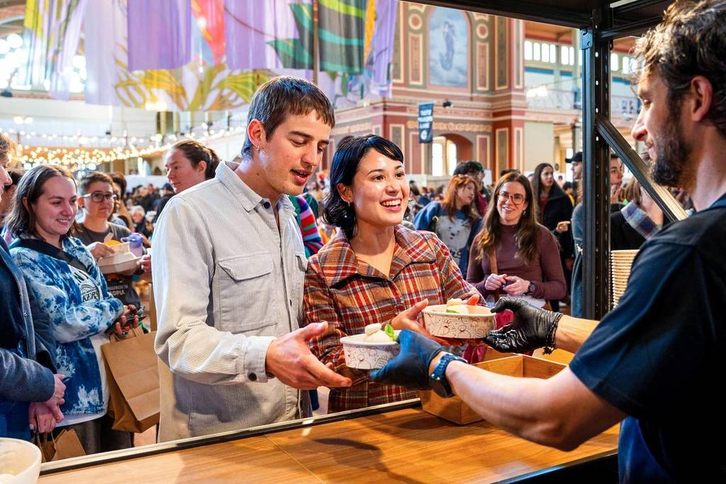 a couple getting a bowl of food at the Big Design Market