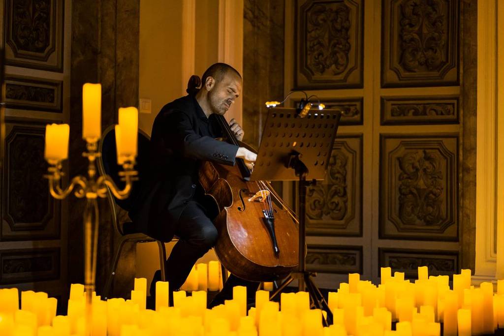 A cellist performing amid a sea of candles at a Candlelight concert