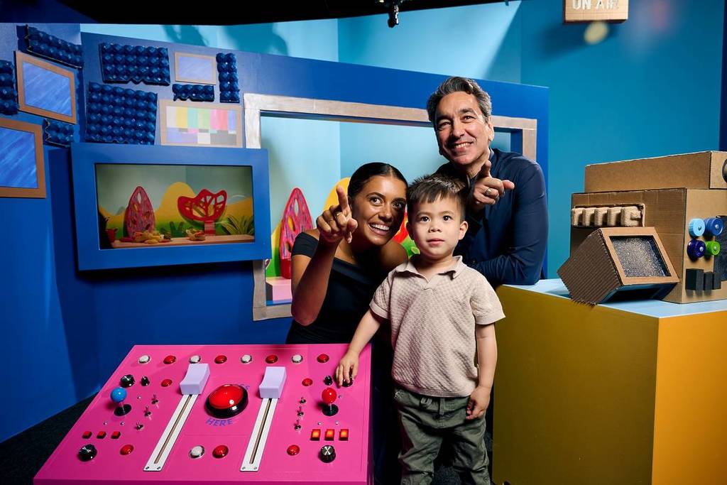 parents showing child something at the Play School exhibition in ACMI