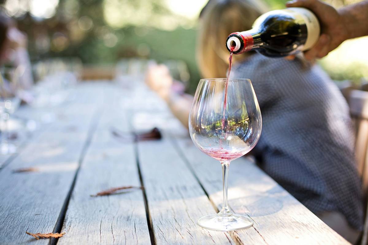 wine poured into glass in vineyard