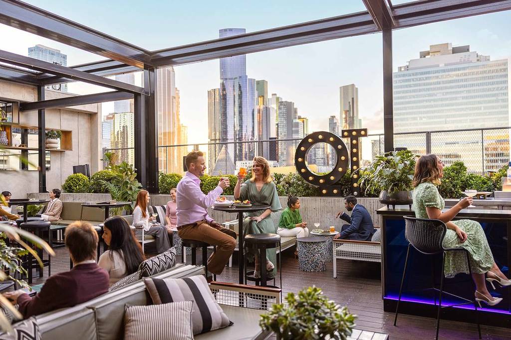 people sipping on drinks on the rooftop of QT Melbourne