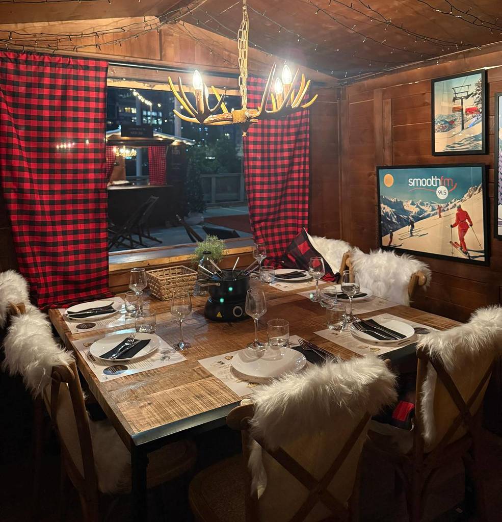 inside of Fondue Chalet, decked out with cosy ski decor and fur throws on chairs