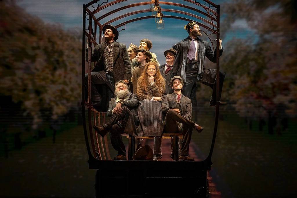 cast of Anastasia the musical sitting on luggage during a train scene