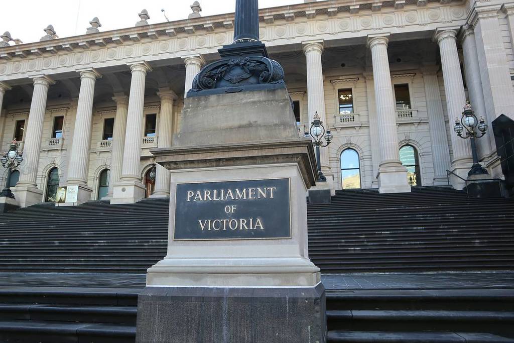 a sign that says 'Parliament of Victoria' in front of steps to parliament house