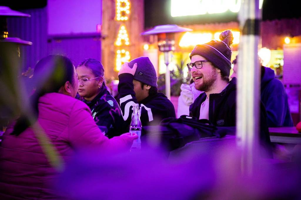 people chatting while sitting and eating or drinking something at Grazeland during winter